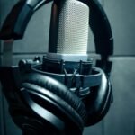 Close-up of condenser microphone with headphones in a music studio.