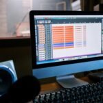 Modern recording studio with computer and mixing console, inside view.